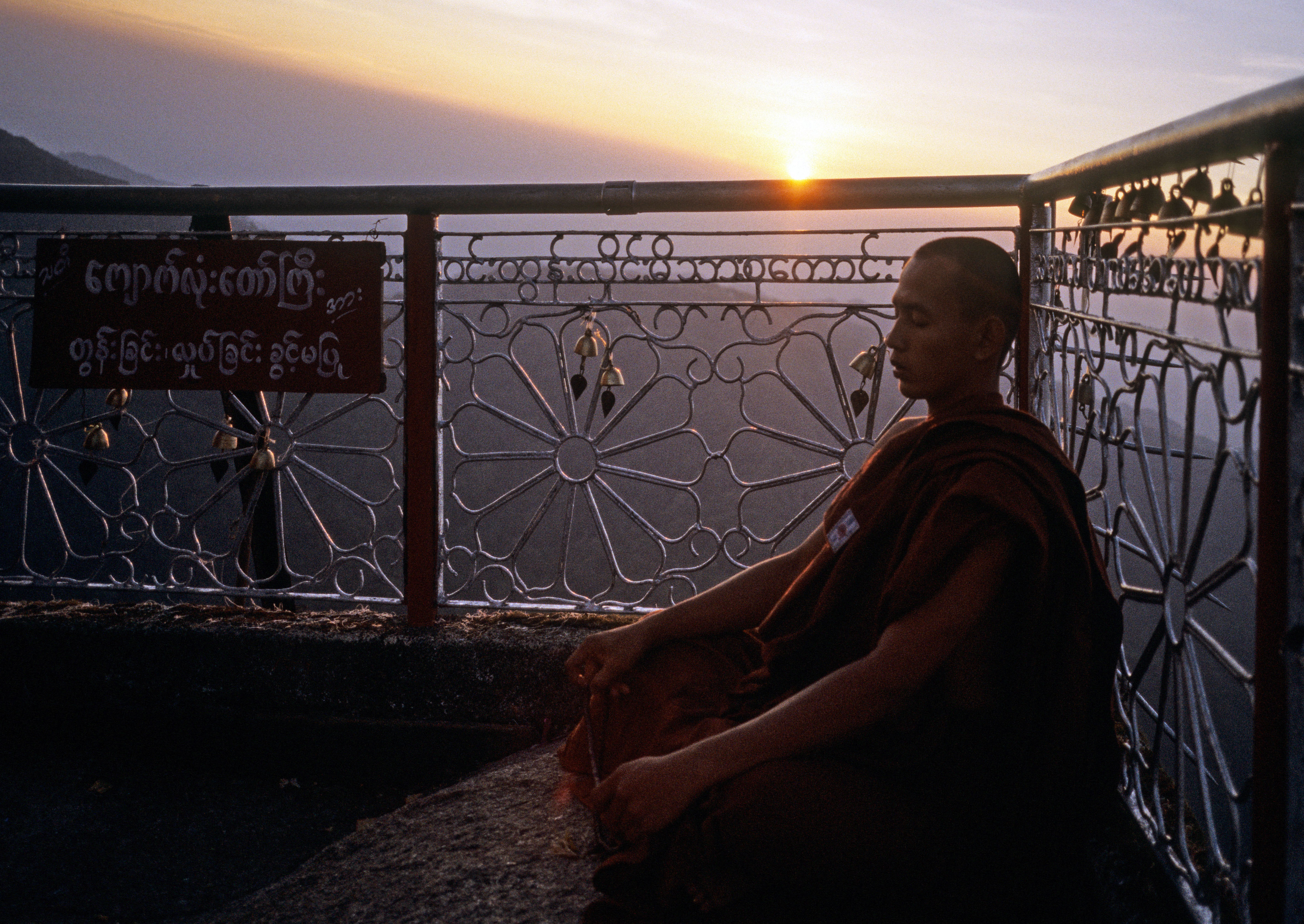 A monk meditates in prayer near the Golden Rock of Kyaik Htee Yoe